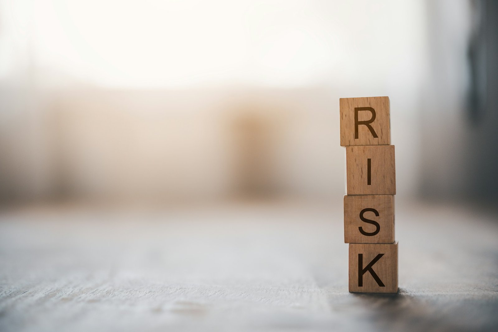 wooden block with the word "RISK". Concept risk management.